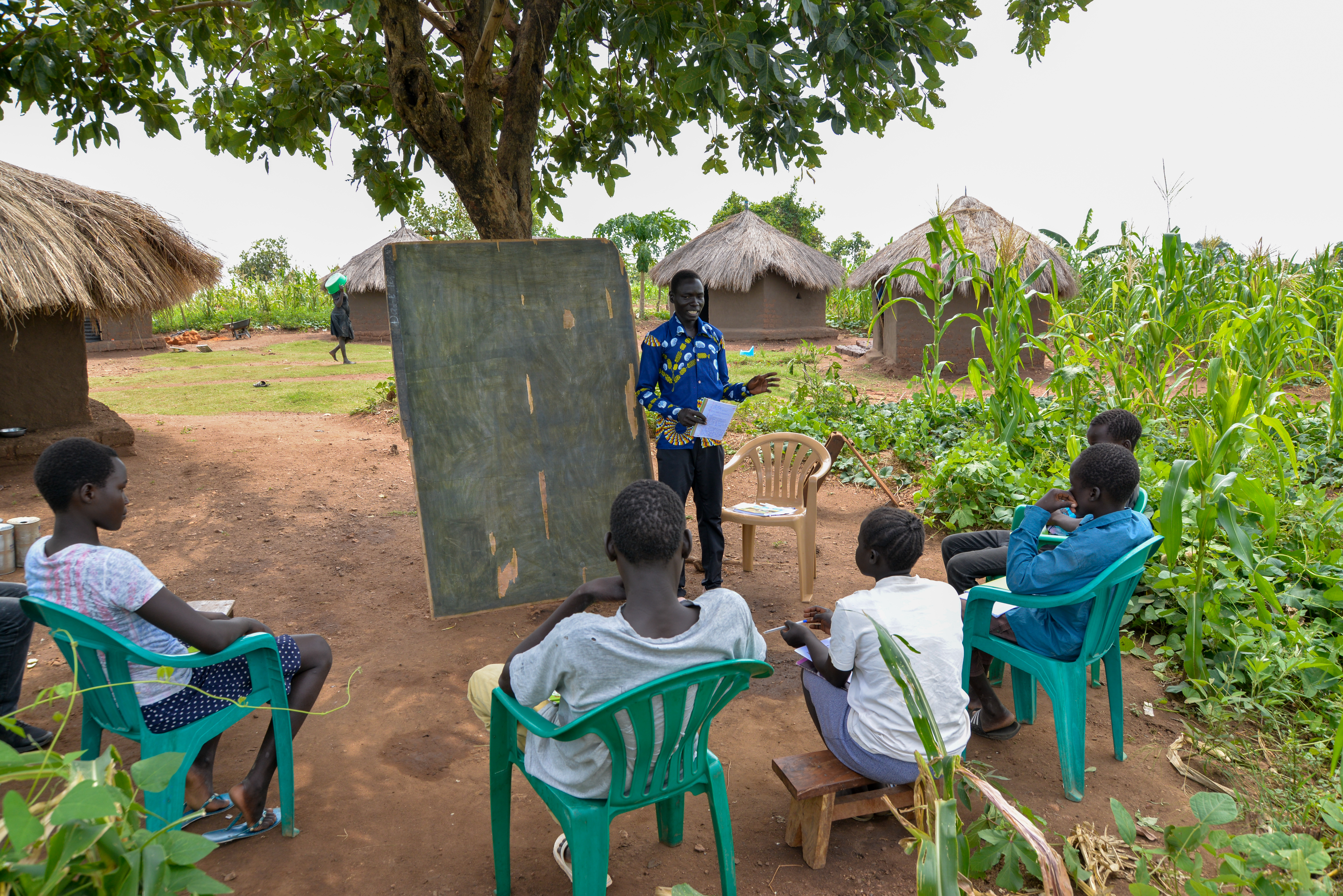 Class sits outside in Uganda, having socially distant lessons due to coronavirus