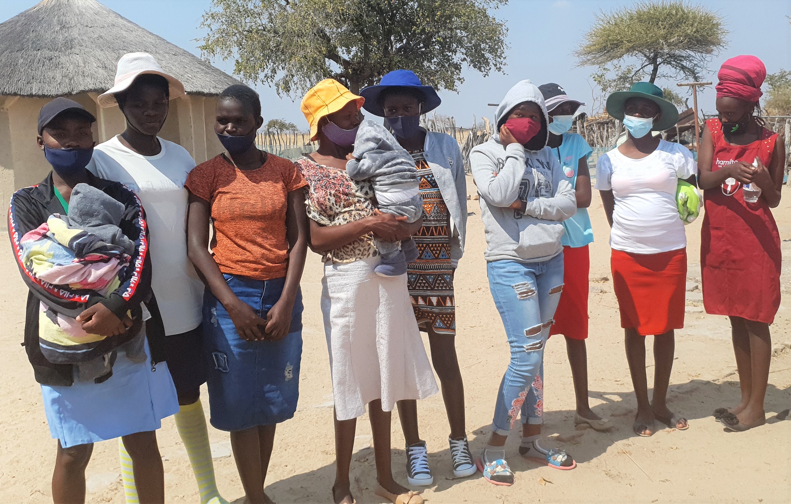 A group of young mums in Zimbabwe stand outside together