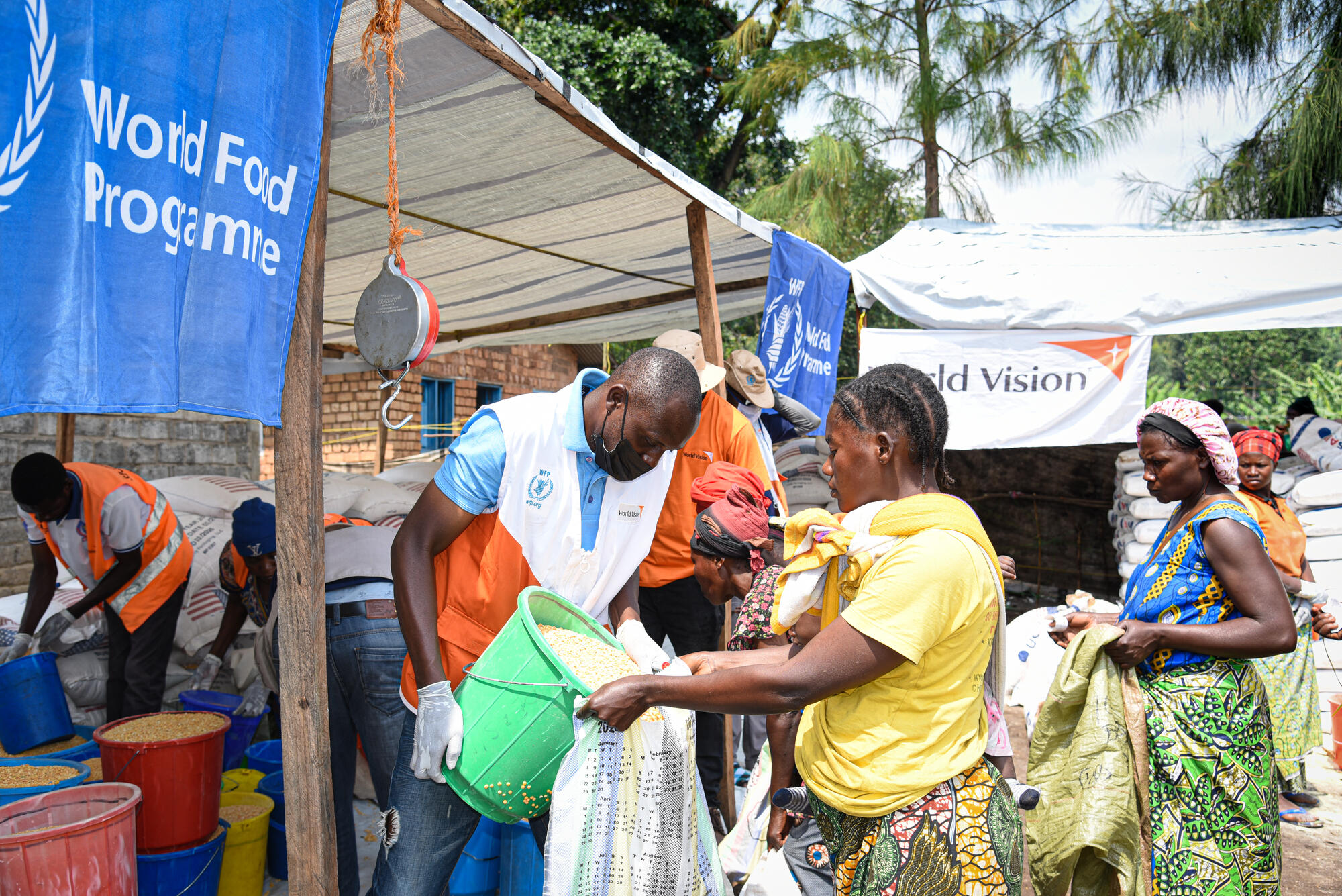 Sifa, 28, an internally displaced woman in the DRC, and her one-year-old daughter, receiving a food ration thanks to support from World Vision and the WFP