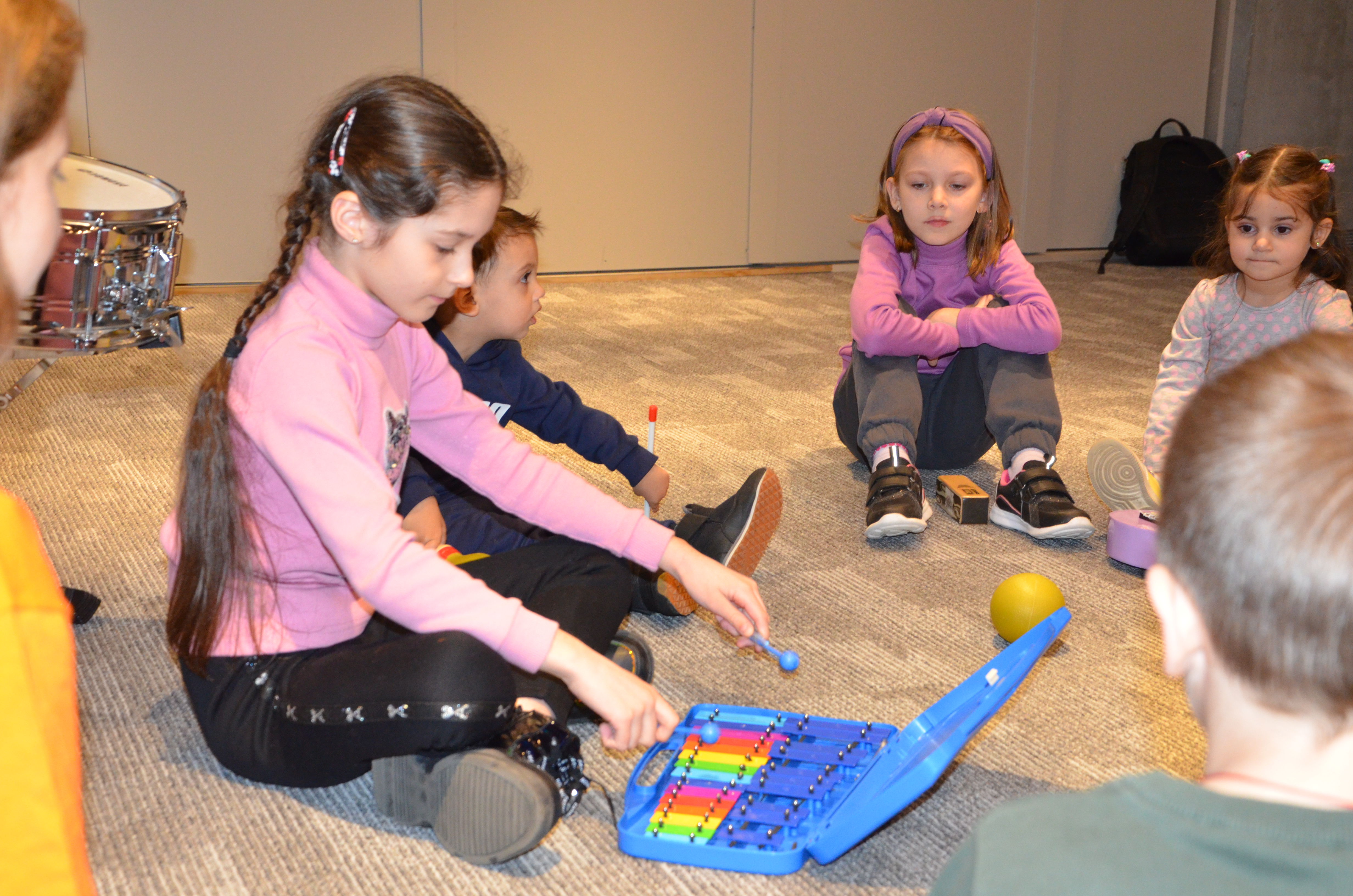 A little girl plays a xylophone 