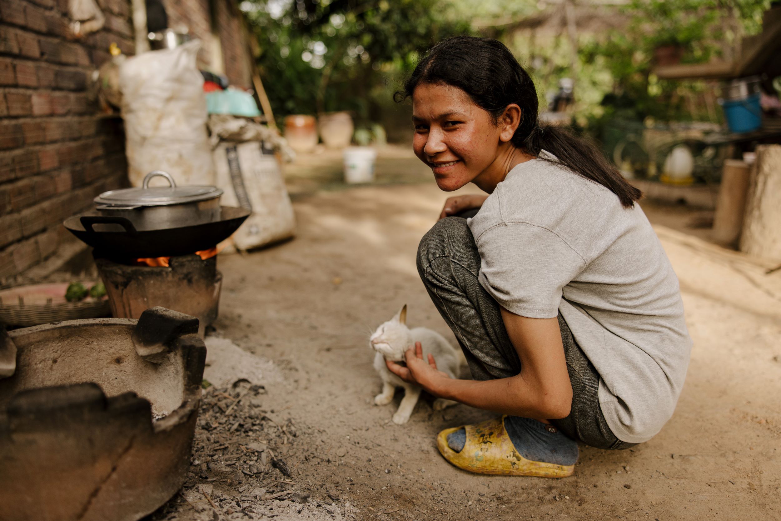 Cambodian girls smiles while posing with kitten