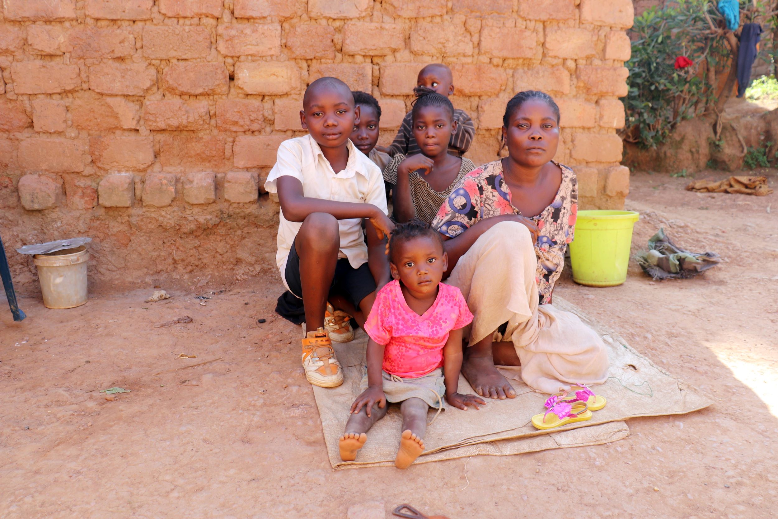 Five children sitting with their mother outside their home in Democratic Republic of Congo