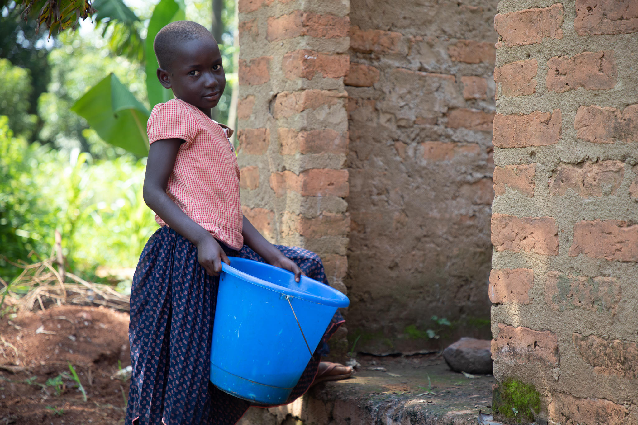 Rome's younger sister making use of the newly built bathroom in Uganda