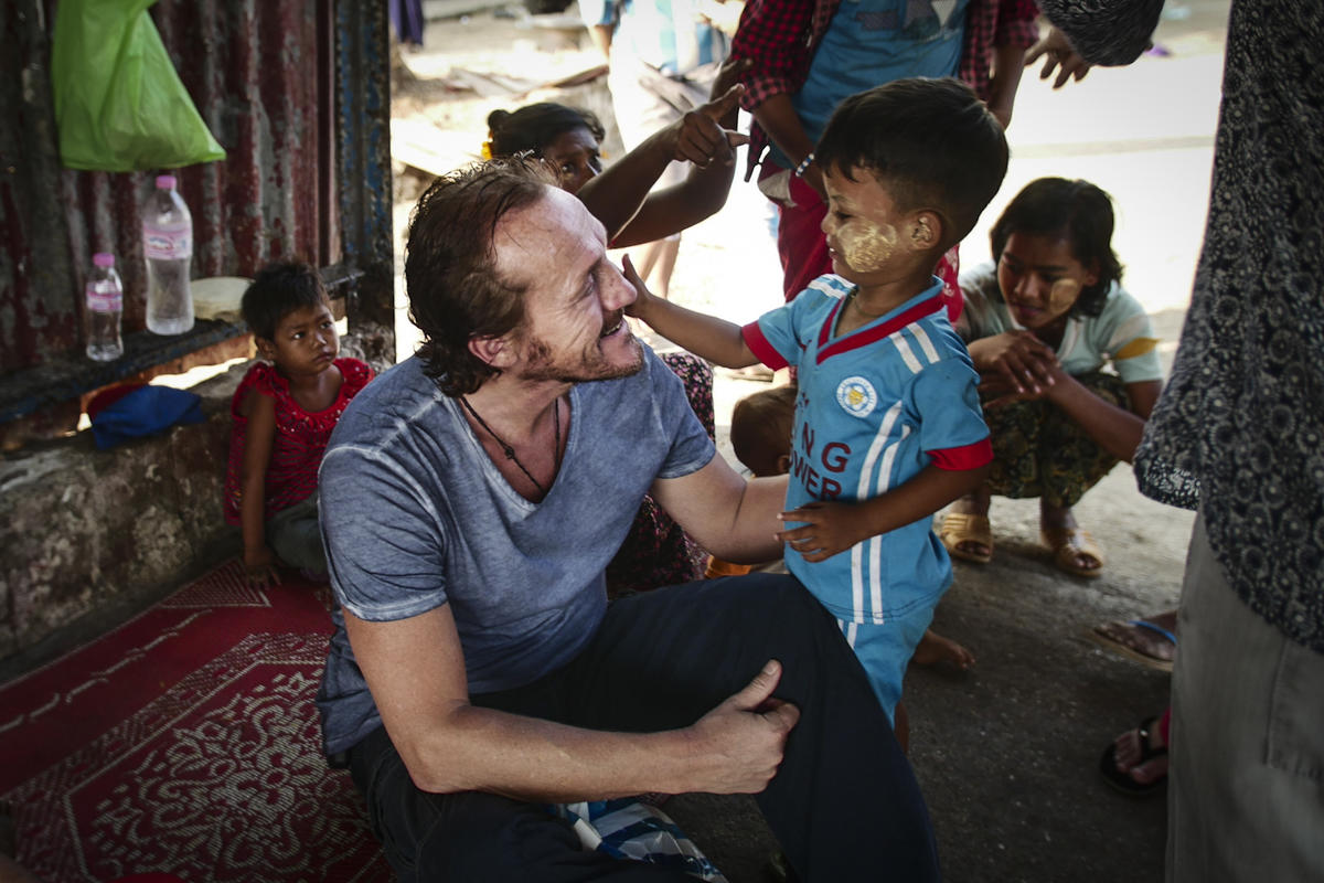 Actor Jerome Flynn talks with a young boy from Myanmar