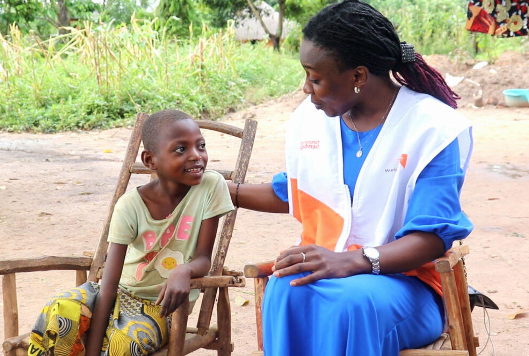 Female World Vision protection officer from DRC talking to cheerful young child