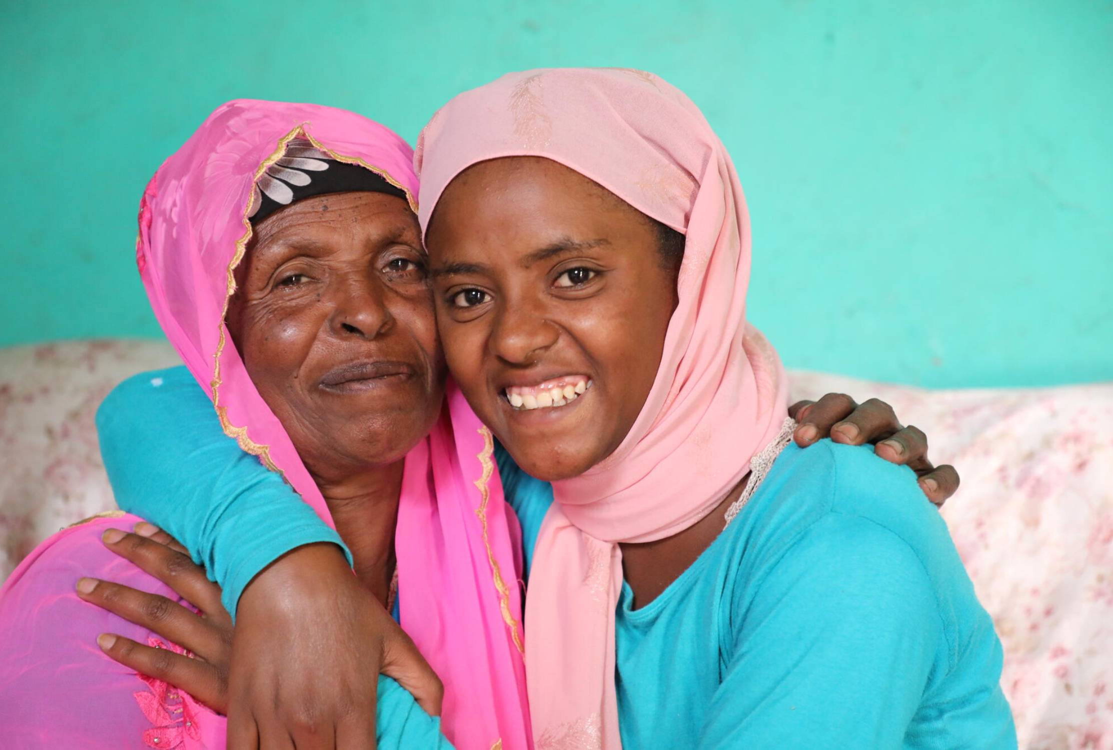 Girl from Ethiopia hugging her local district's Women, Children and Youth Affairs Office representative