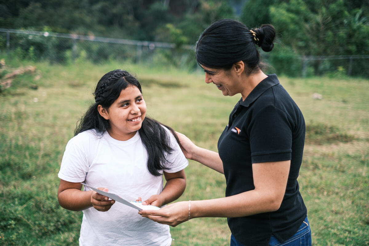 Girl from Honduras showing World Vision staff the letter for her sponsor