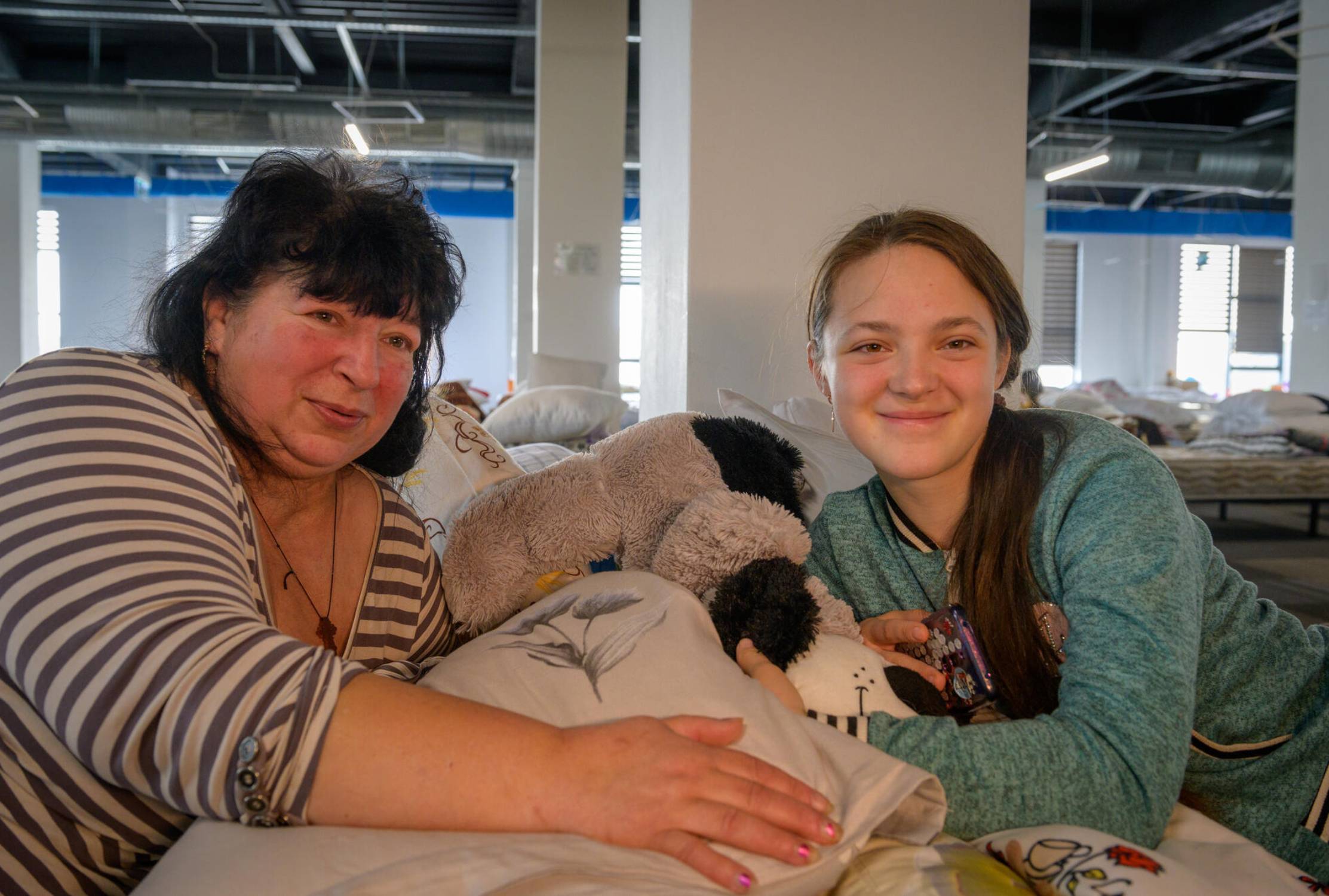 Ukrainian mother and daughter sat together in a refugee centre