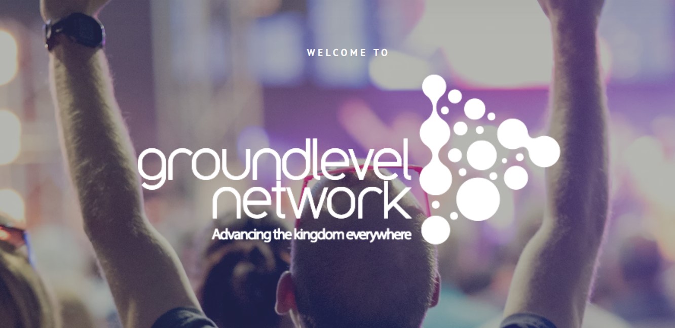 Man at event with hands raised in praise