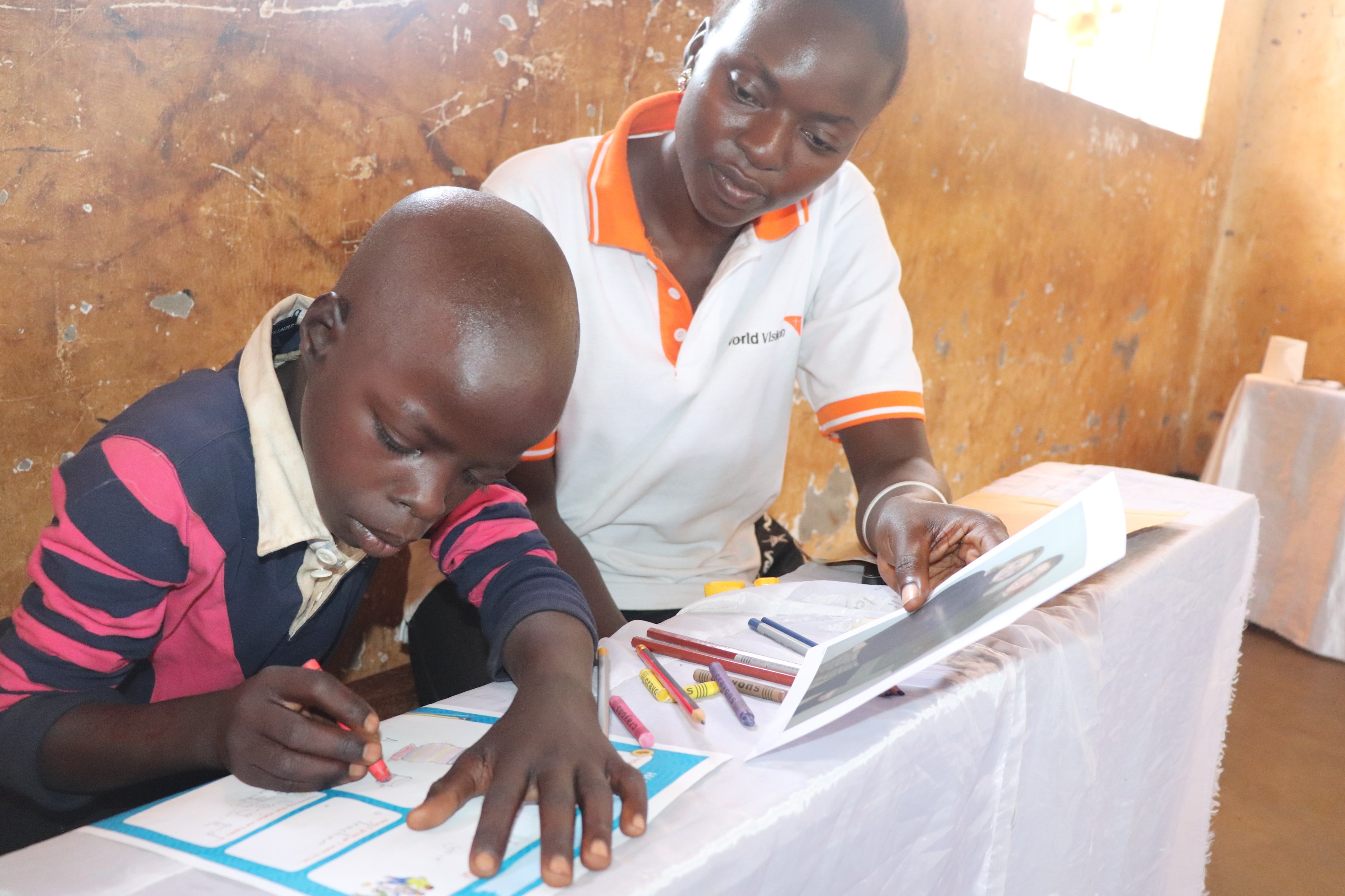 A child studies alongside a World Vision worker