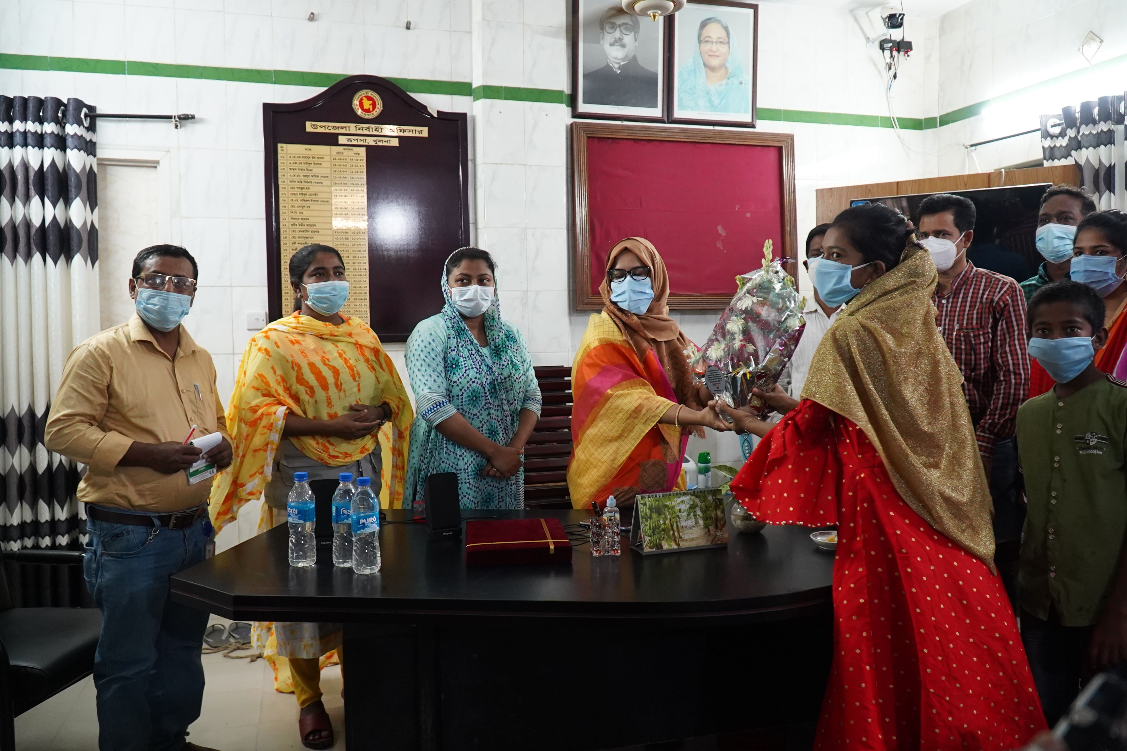 A girl receives a Crest and bouquet of flowers in Bangladesh