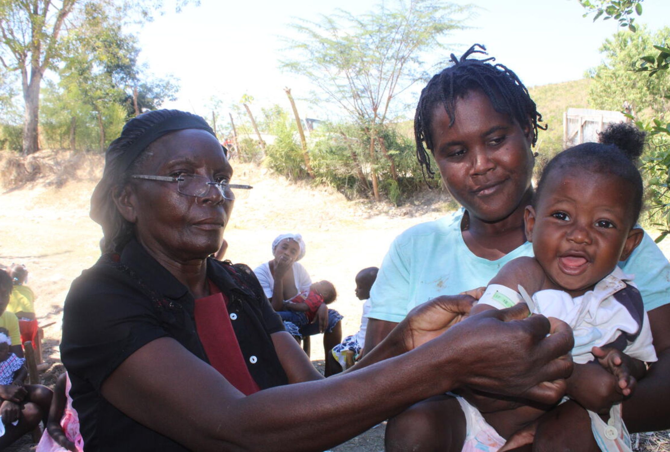 World Vision staff member measuring a girl's arm as part of a malnutrition screening
