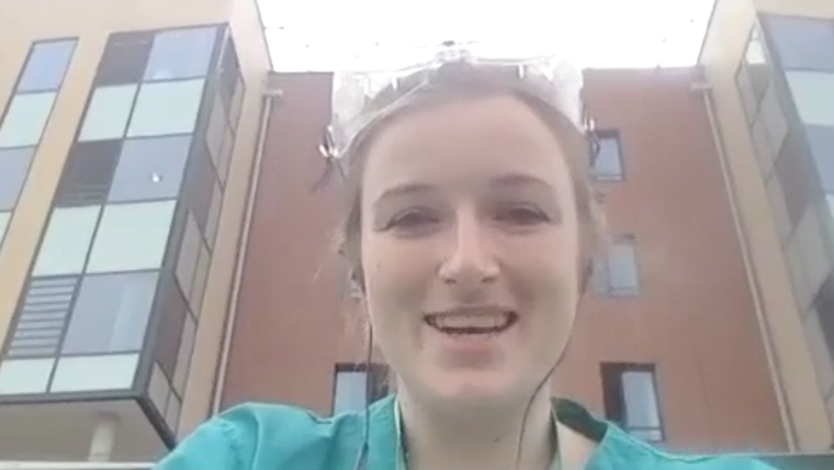 UK medic smiles, wearing scrubs outside her hospital where she has been treating COVID-19 patients
