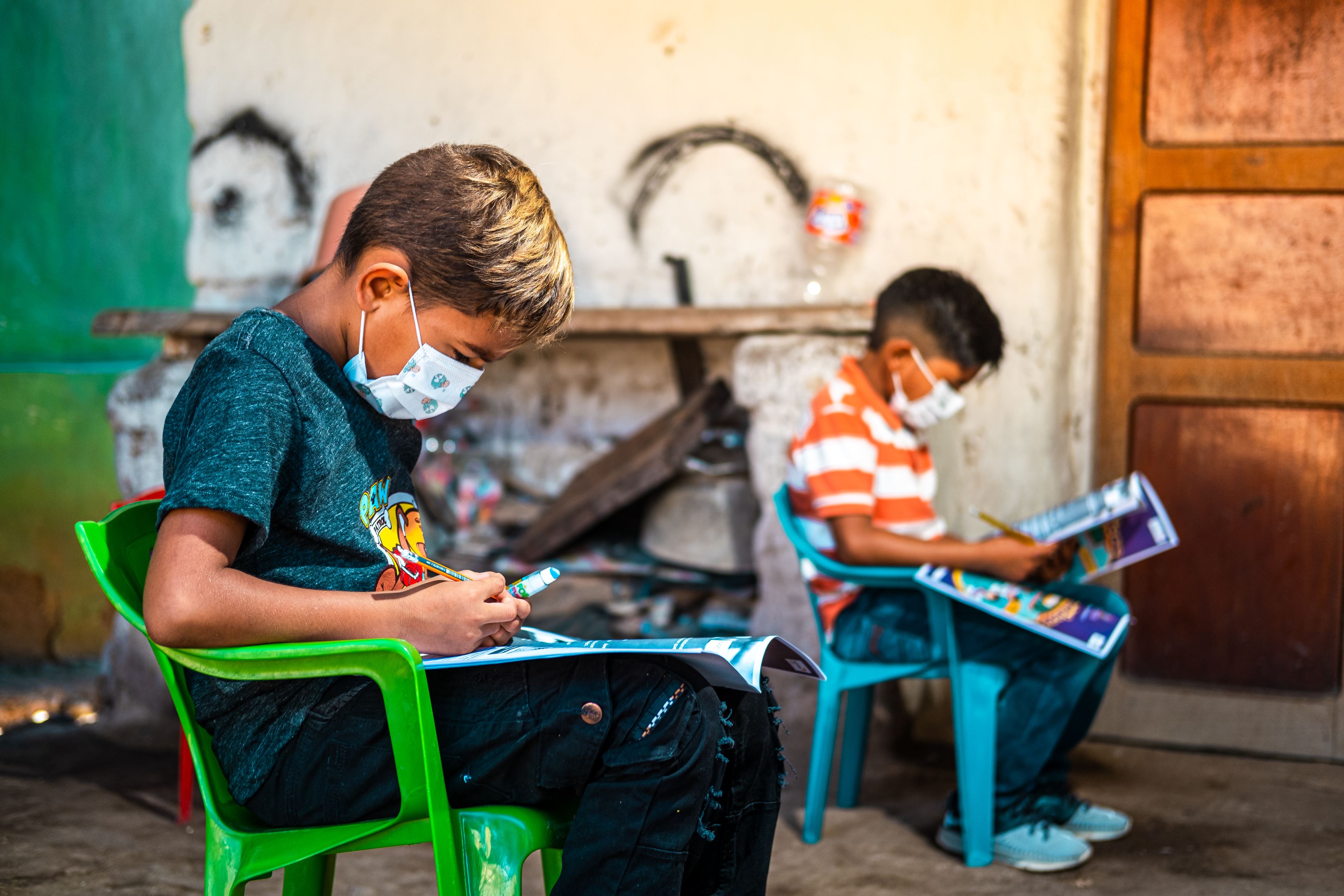 Two children sat in chairs looking at their books