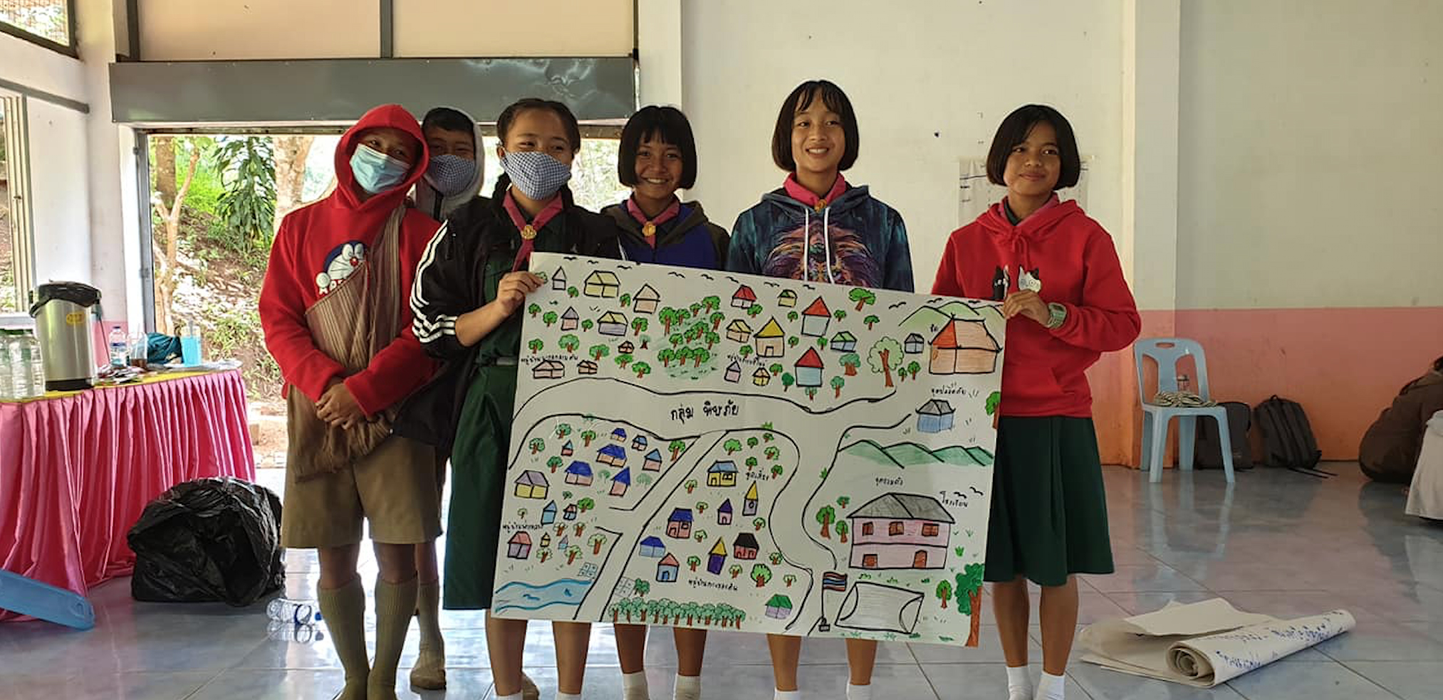 A group in Thailand hold up a poster of a disaster plan they have created
