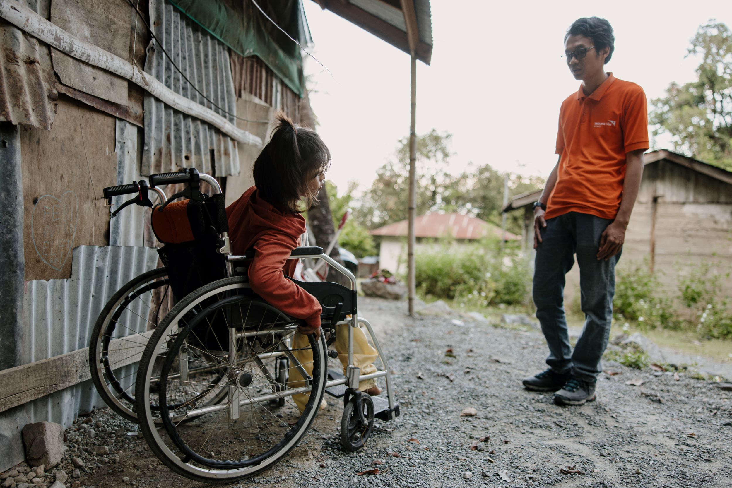 Girl in wheelchair with member of World Vision staff