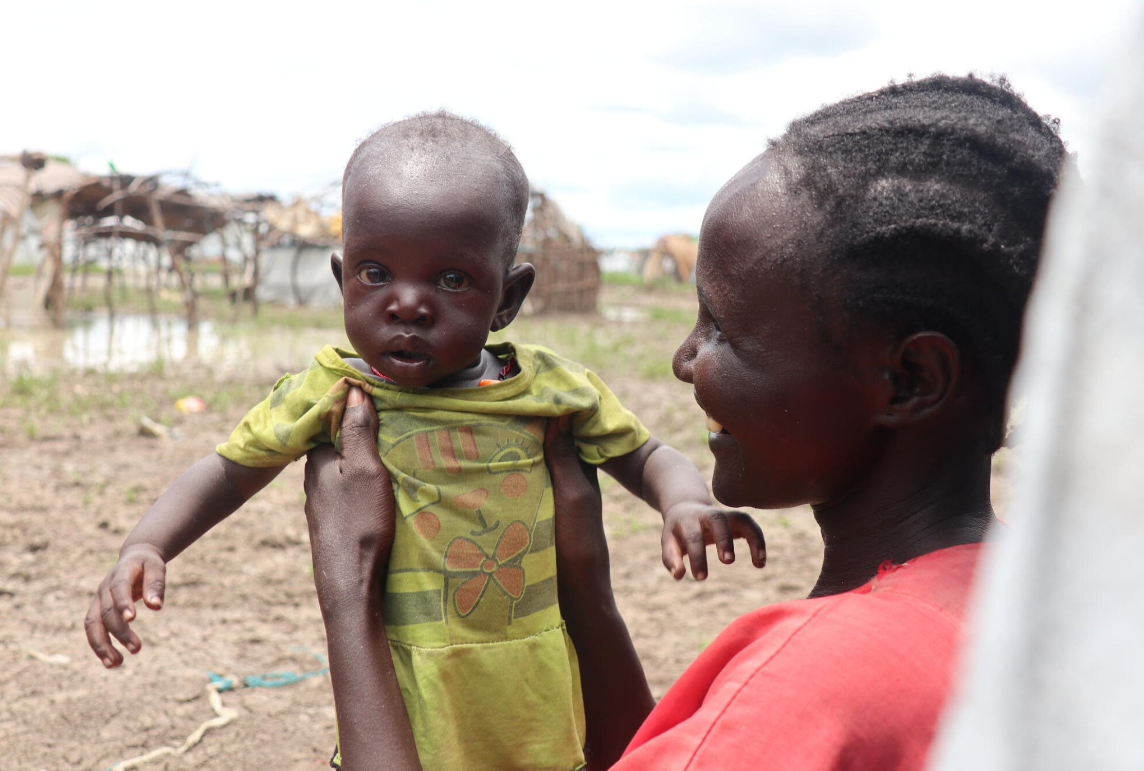 South Sudanese mother holding up her daughter.
