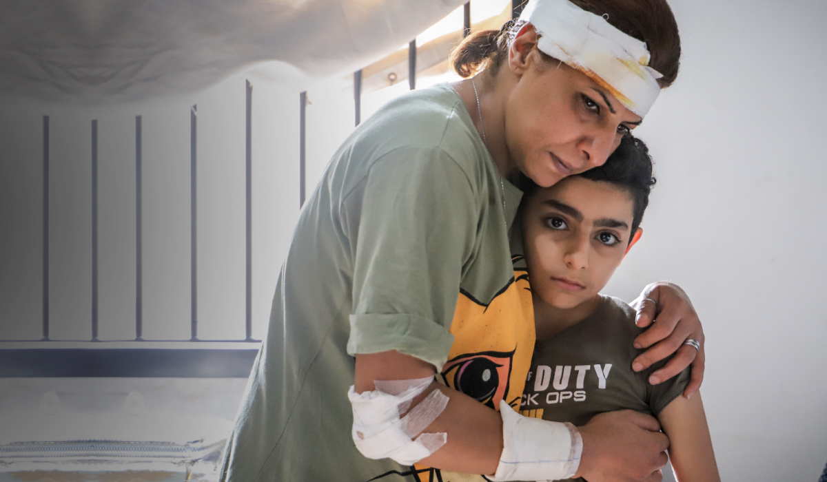Mother with bandages on her head and arms cradles her son after the Beirut explosion