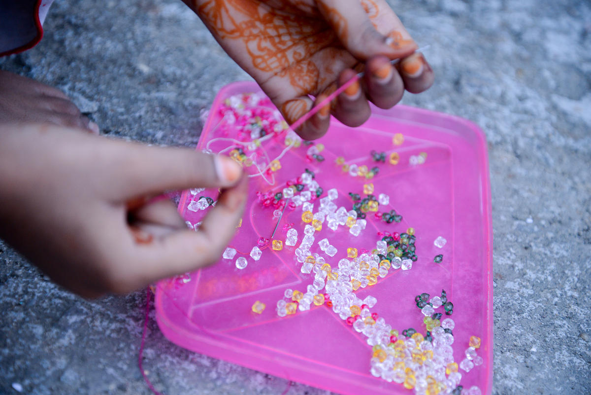 Sonali's hands showing the beads she used to use to make bracelets