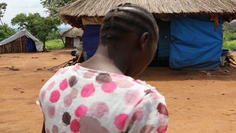 Eva stands with her back to the camera