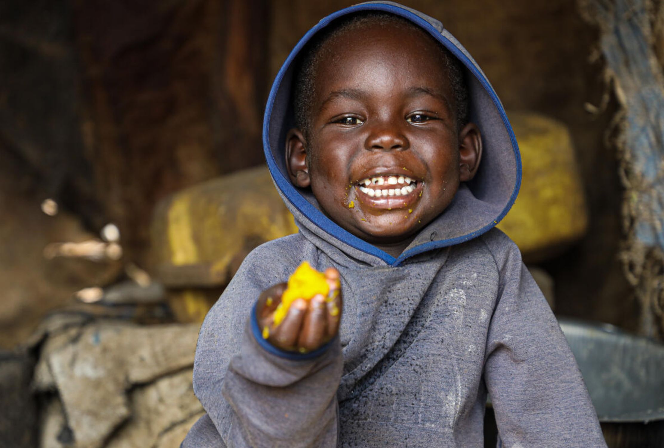 Three-year-old refugee boy from Uganda enjoys eating nutritious food