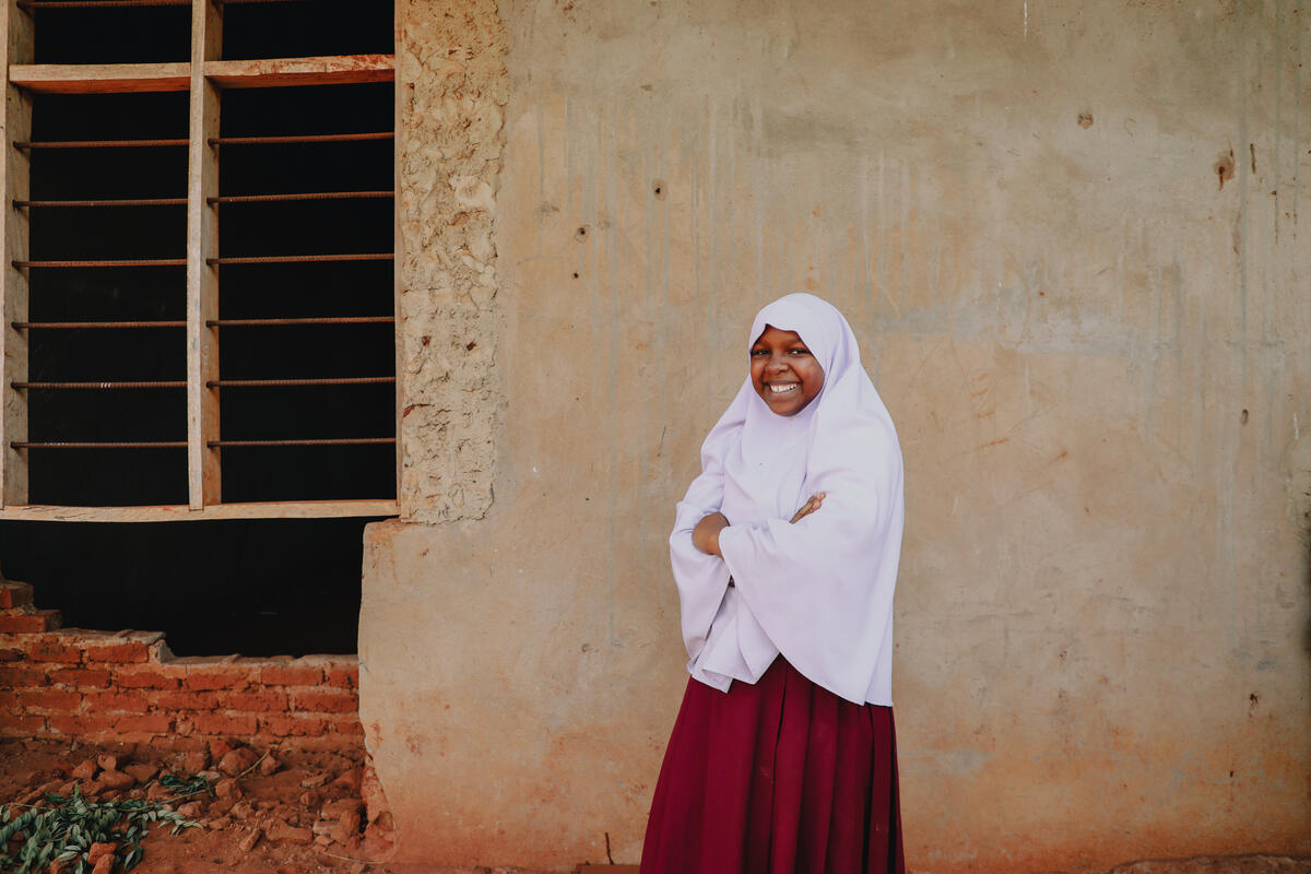 Girl from Tanzania wearing a headscarf and crossing arms 