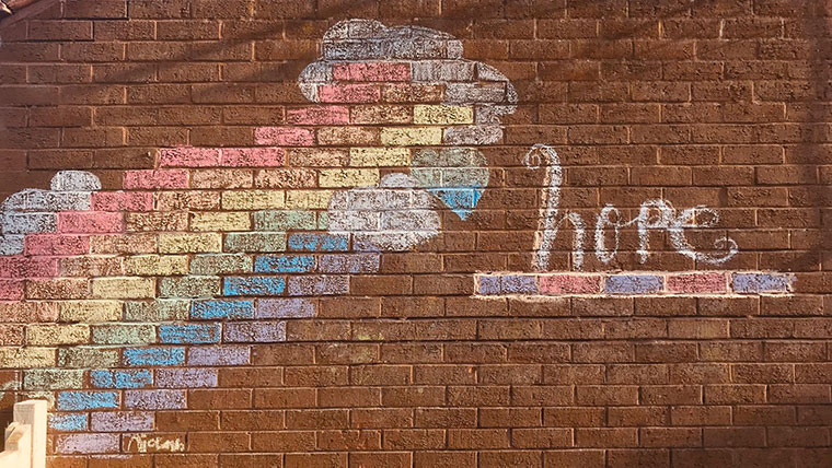 A brick wall mural reads 'hope' and has the colours of a rainbow, to support people during coronavirus 