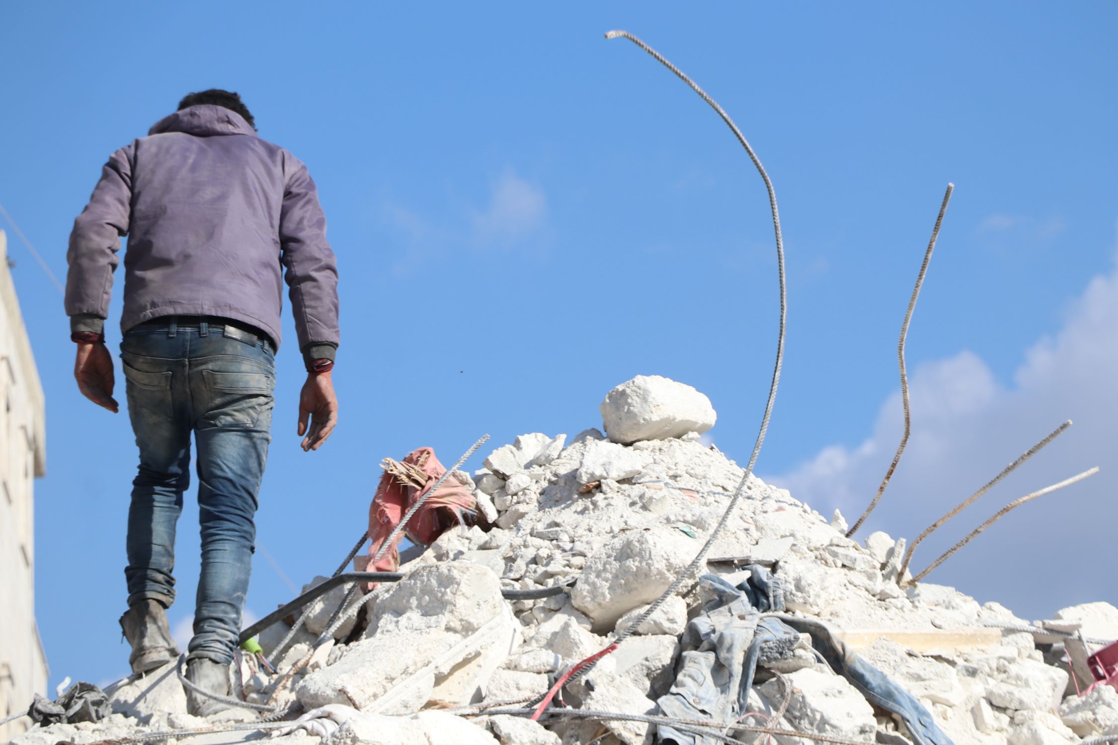Syrian man standing on the rubble of a building