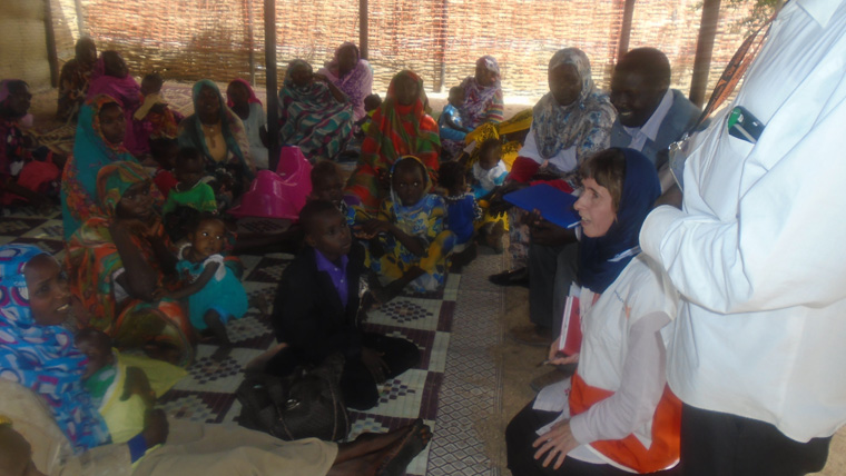 Room of people sit on the floor together in Sudan to discuss the local World Vision-World Food Programme