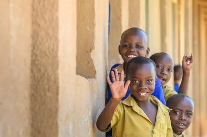 Children from a Rwanda waving at the camera