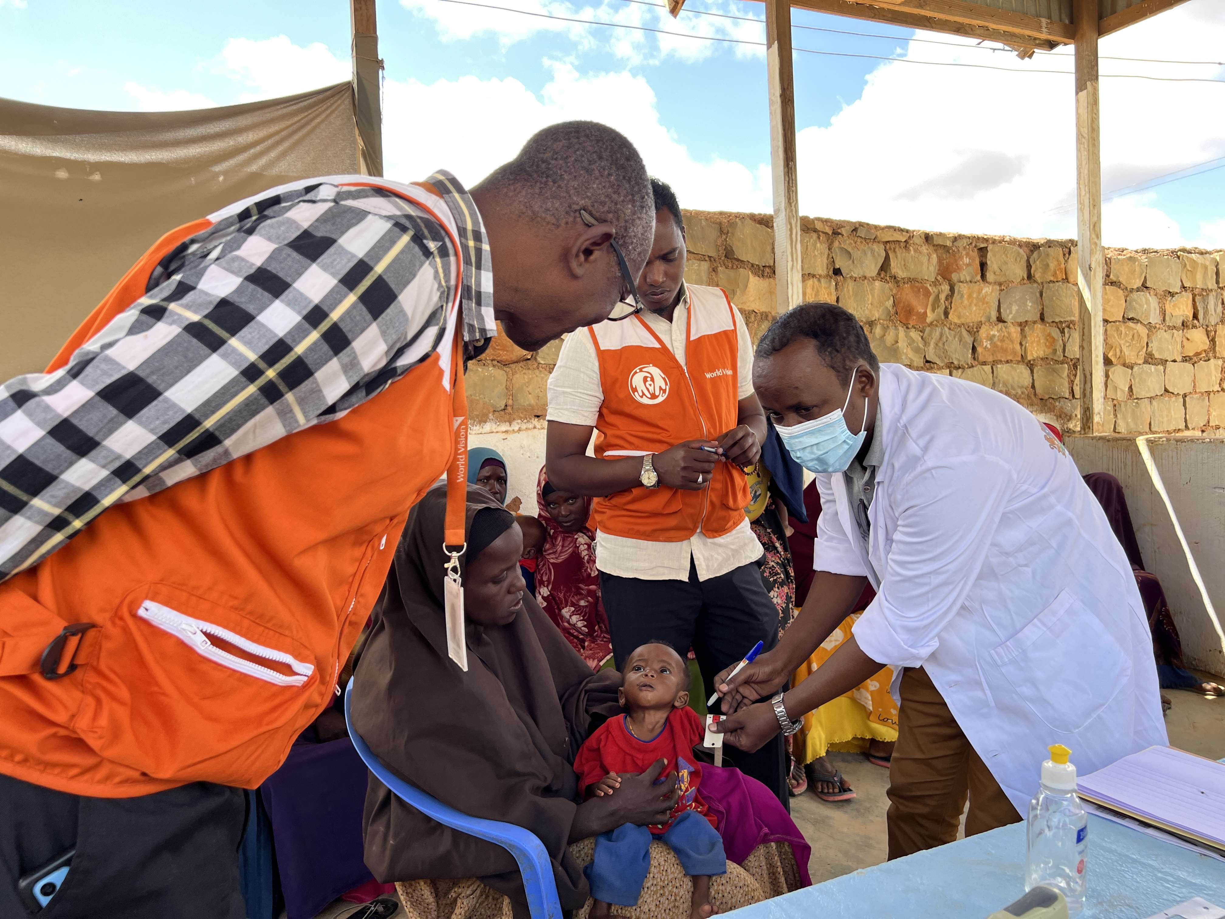 World Vision Director and a healthcare worker in Somalia attending to a malnourished 8-month old baby.