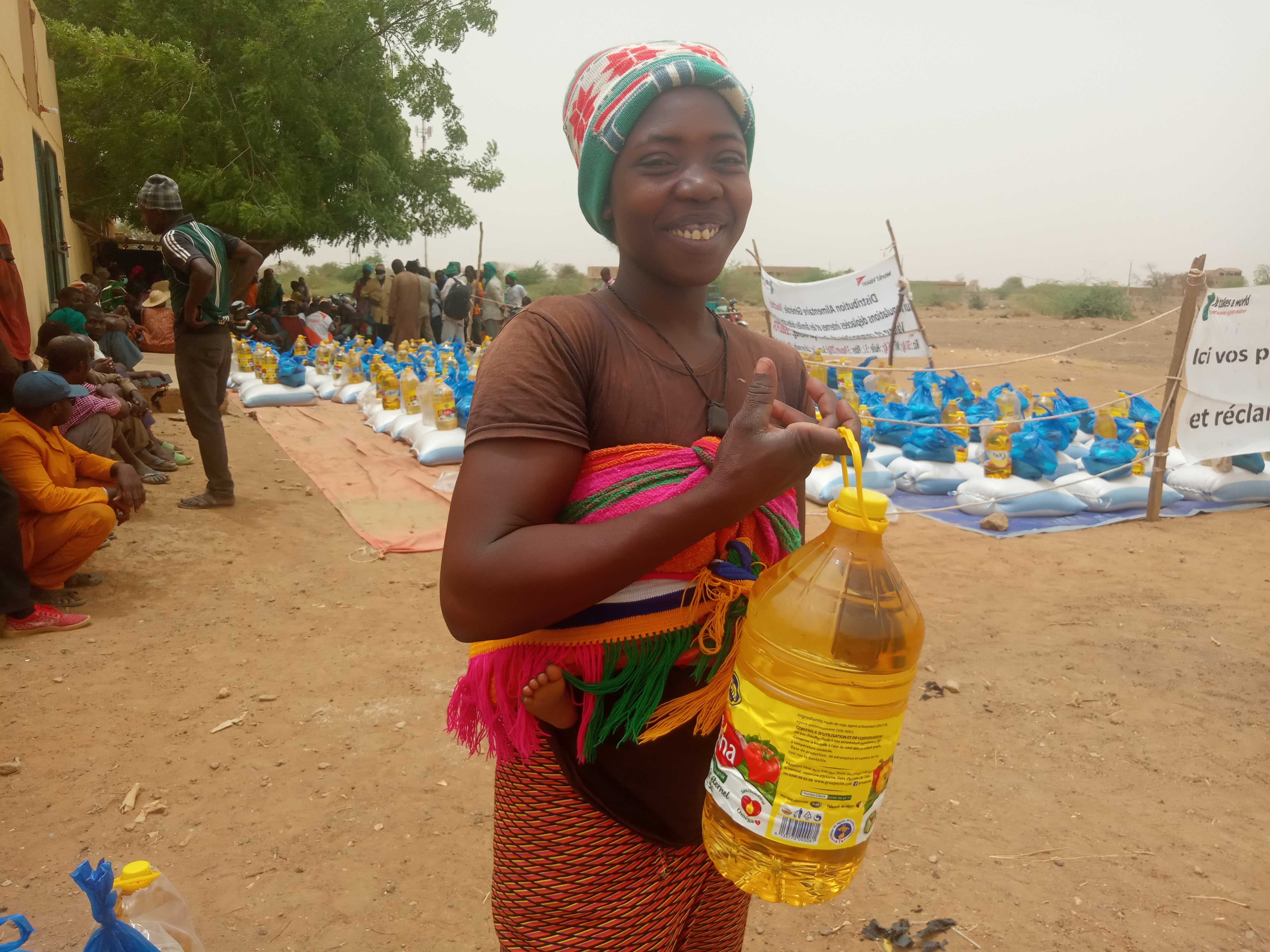 Mum Habiba smiles as she collects cooking oil at the food distribution in Mali