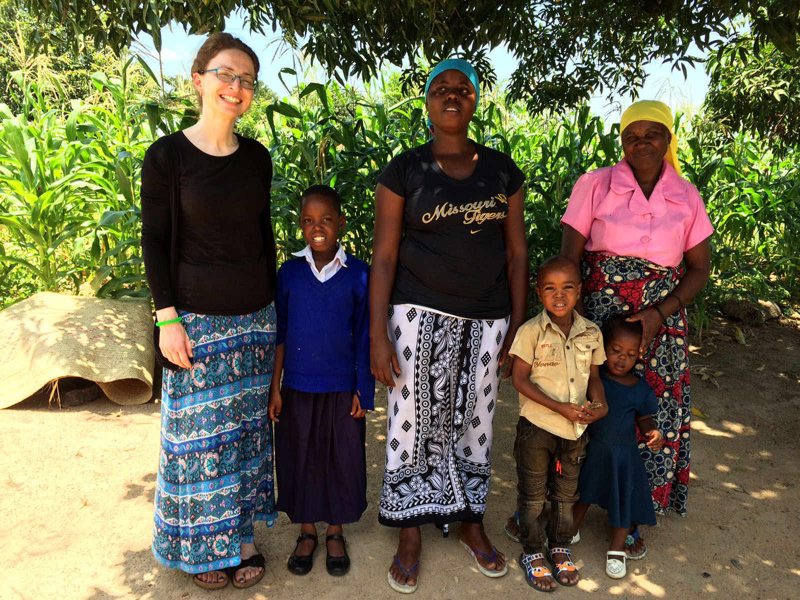 Three women and two children stand together outside in Tanzania