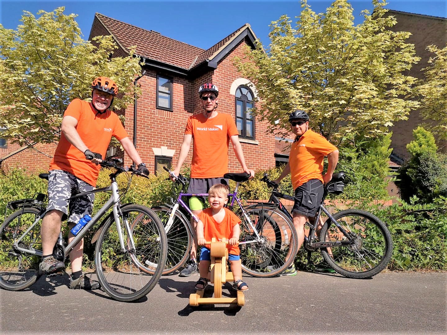 UK family of four pose with bicycles in orange t-shirts to raise funds to protect children from coronavirus