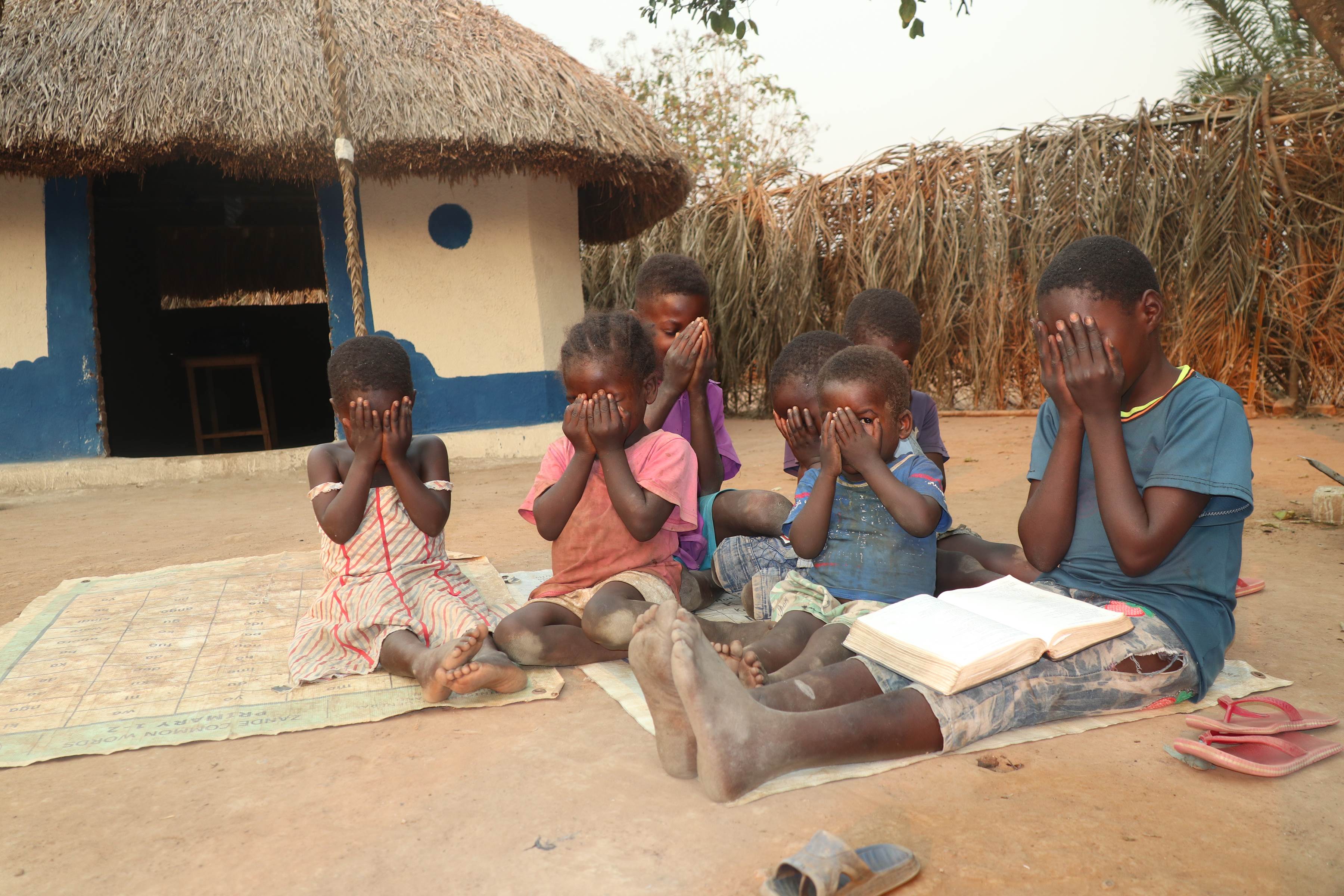 Moses, 8, leads other children in prayer in South Sudan.
