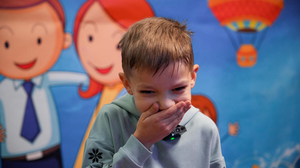 A young Ukrainian boy covers his mouth with his hand.