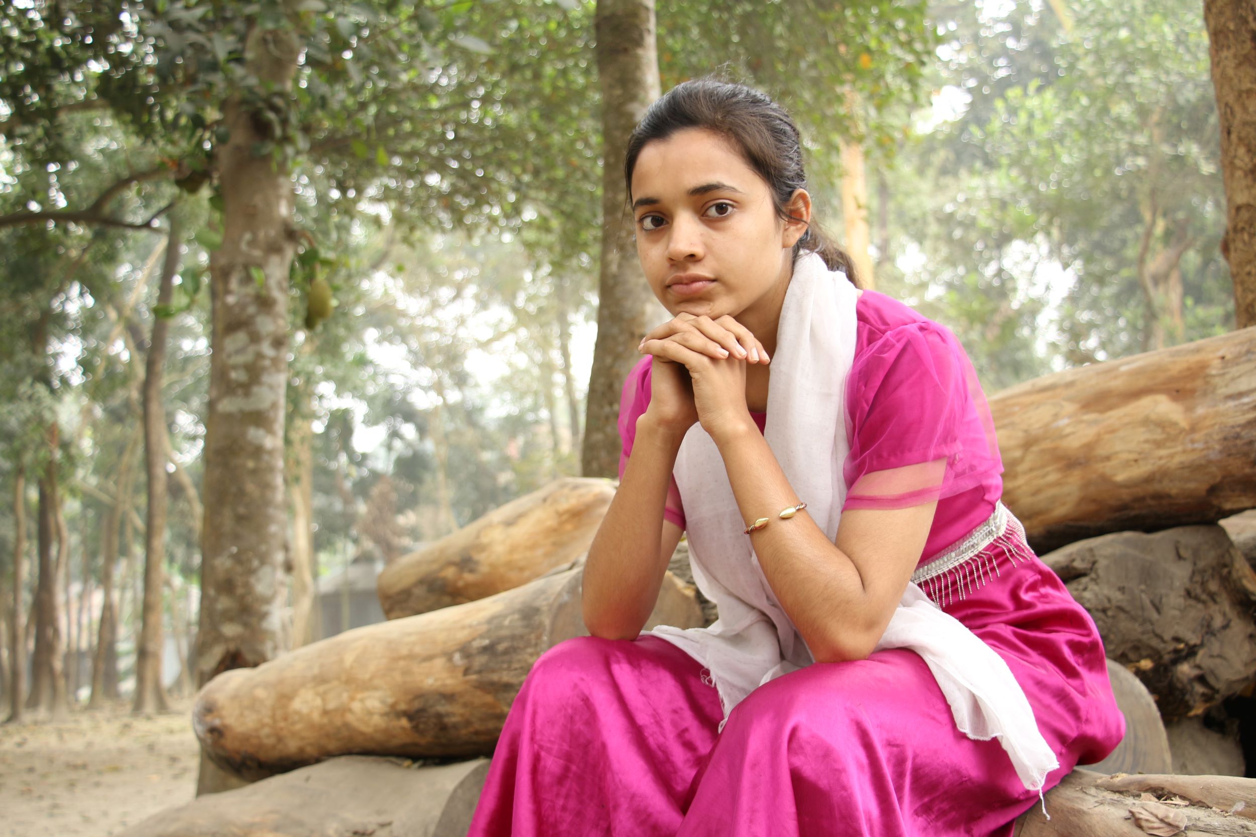 Girl, Bangladesh, sitting in a wooded area