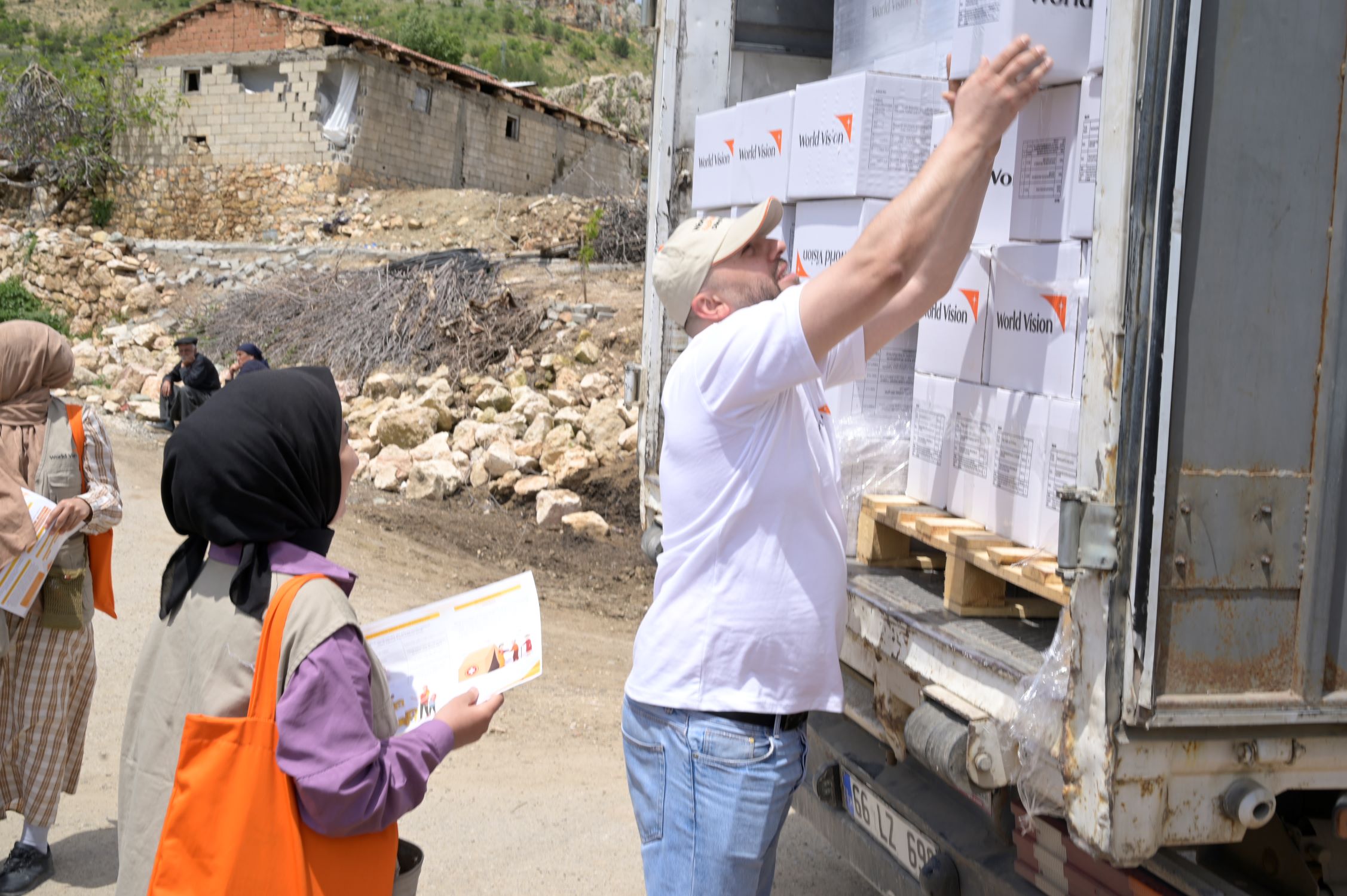 World Vision worker and truck driver unloading aid for earthquake victims