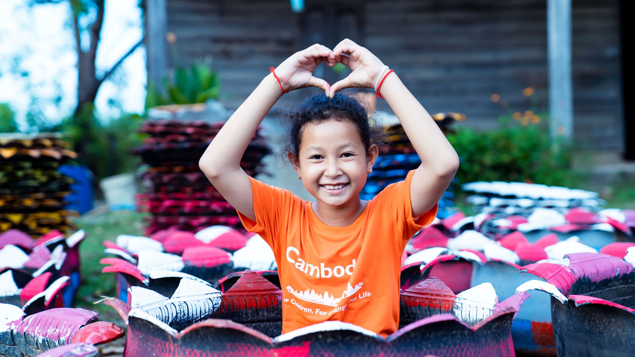Girl making heart shape at World Vision project, Cambodia