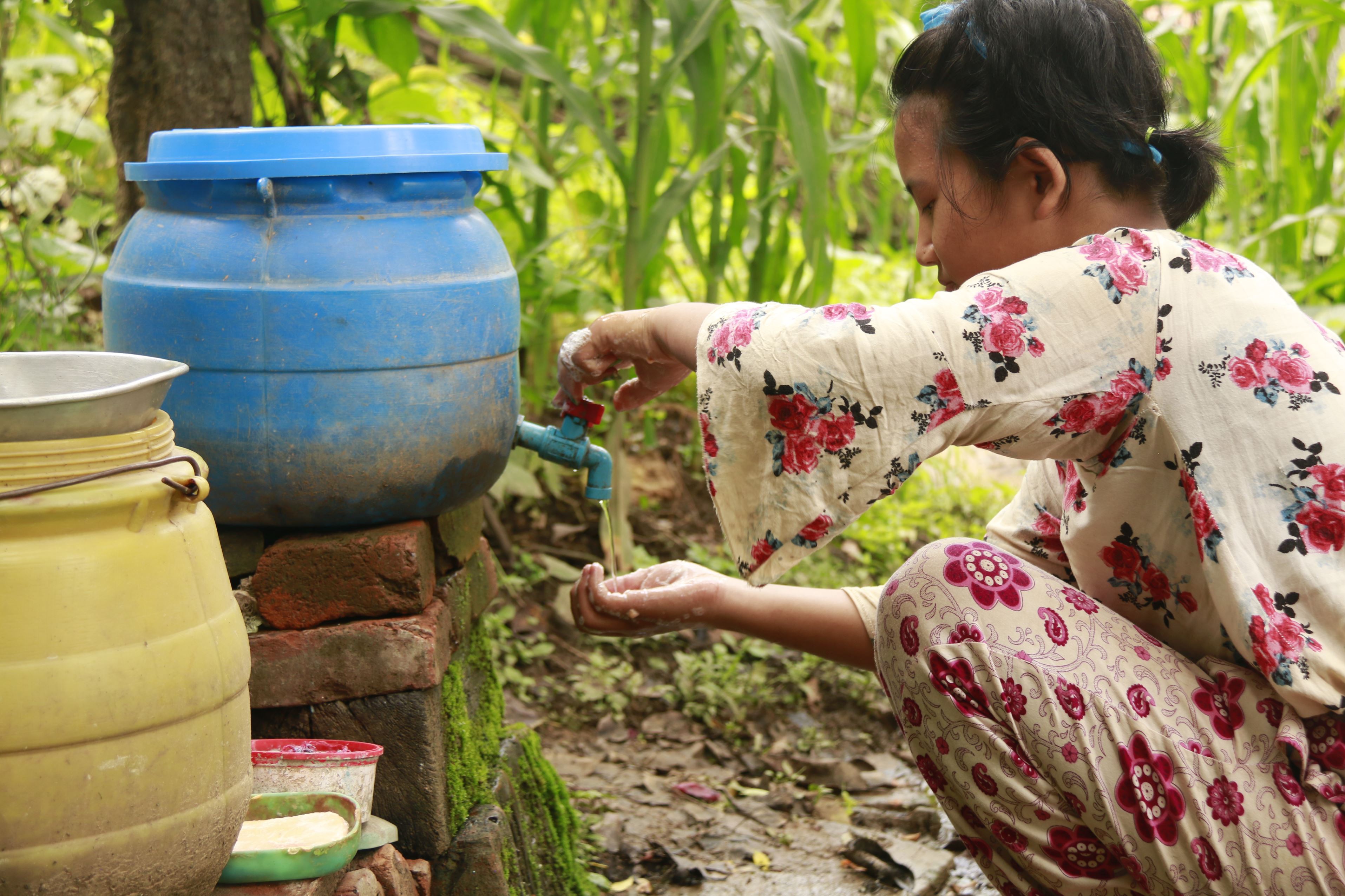 Girl in Nepal pouring clean water