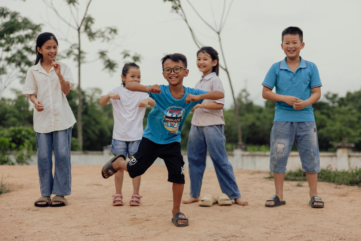 A sponsored child and his four peers dancing outside