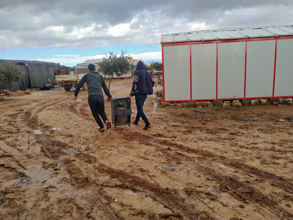 Two World Vision representatives delivering an electric heater to victims of the earthquake n Syria.