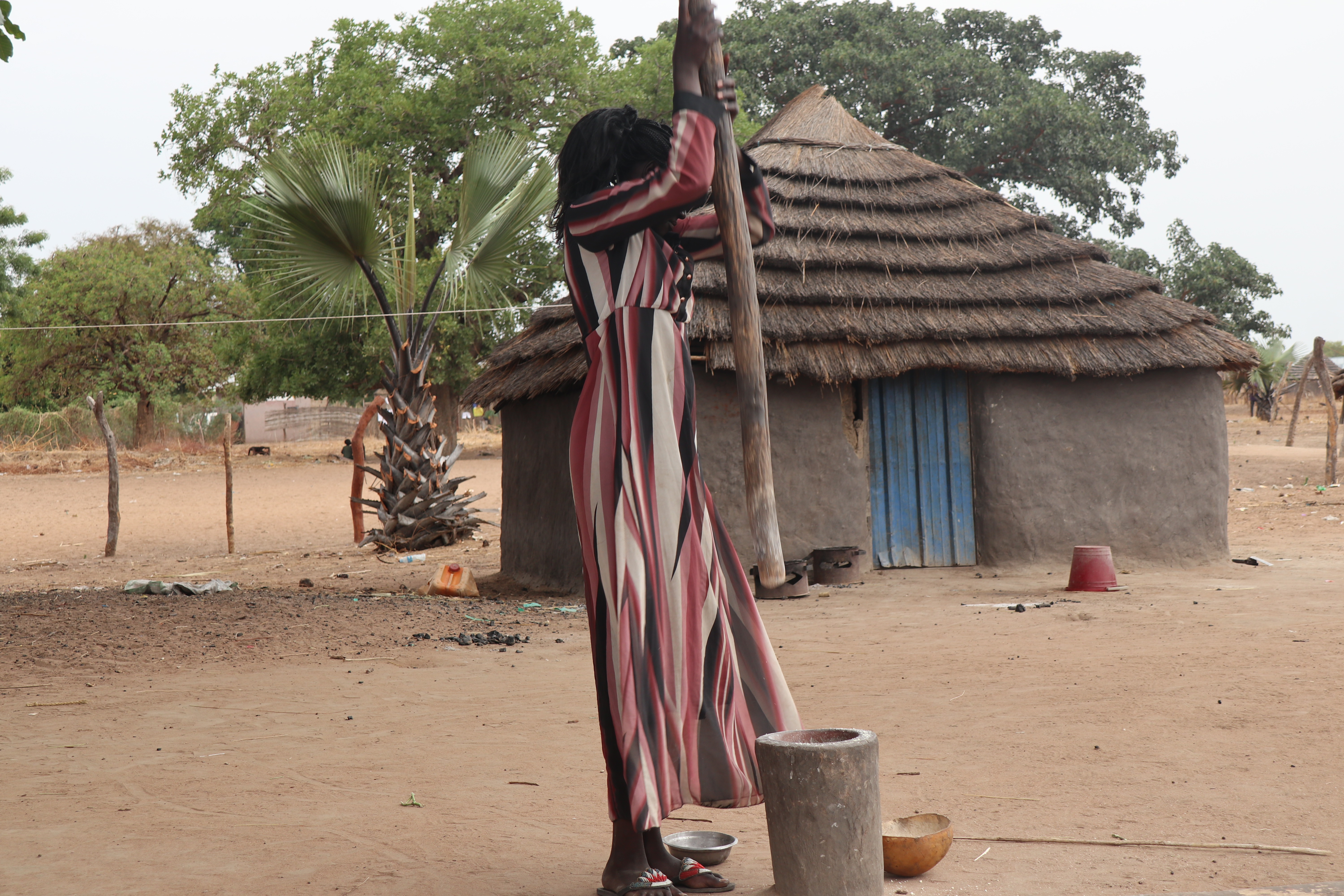 Katina churns butter outside her home