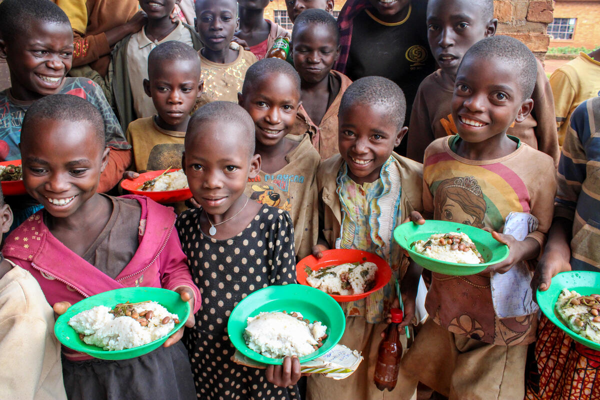 Group of school children holding plates of food.