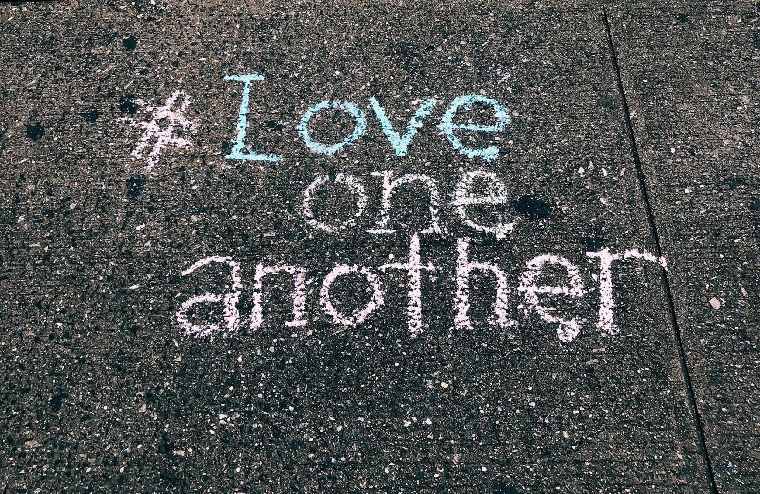 Love one another in chalk on pavement