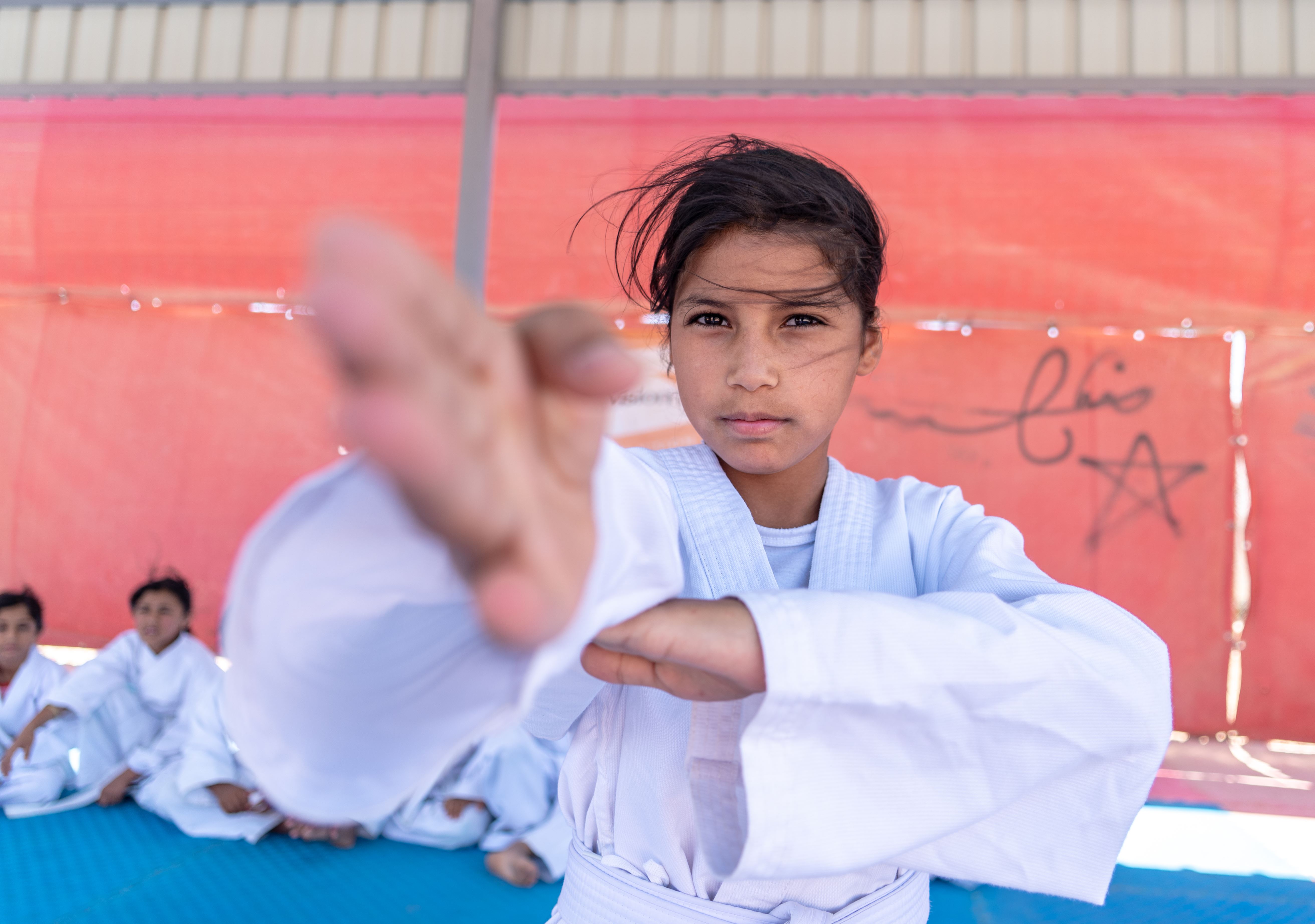 Girl in Jordan wears a robe as she demonstrates a self defense move