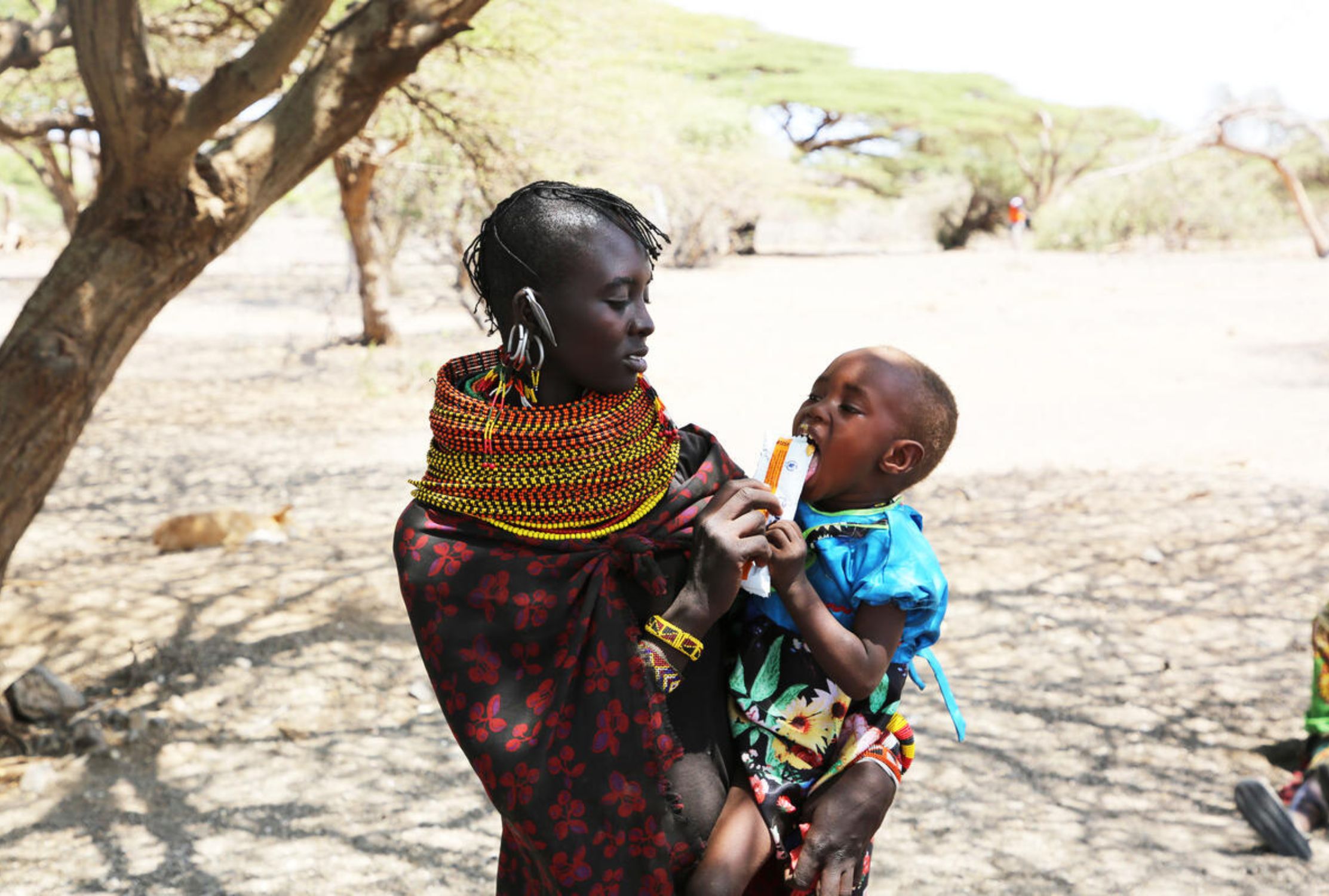 Kenyan mother holding and feeding her baby girl.