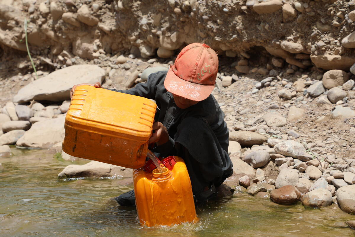 Afghan child collecting water from an unsafe source.