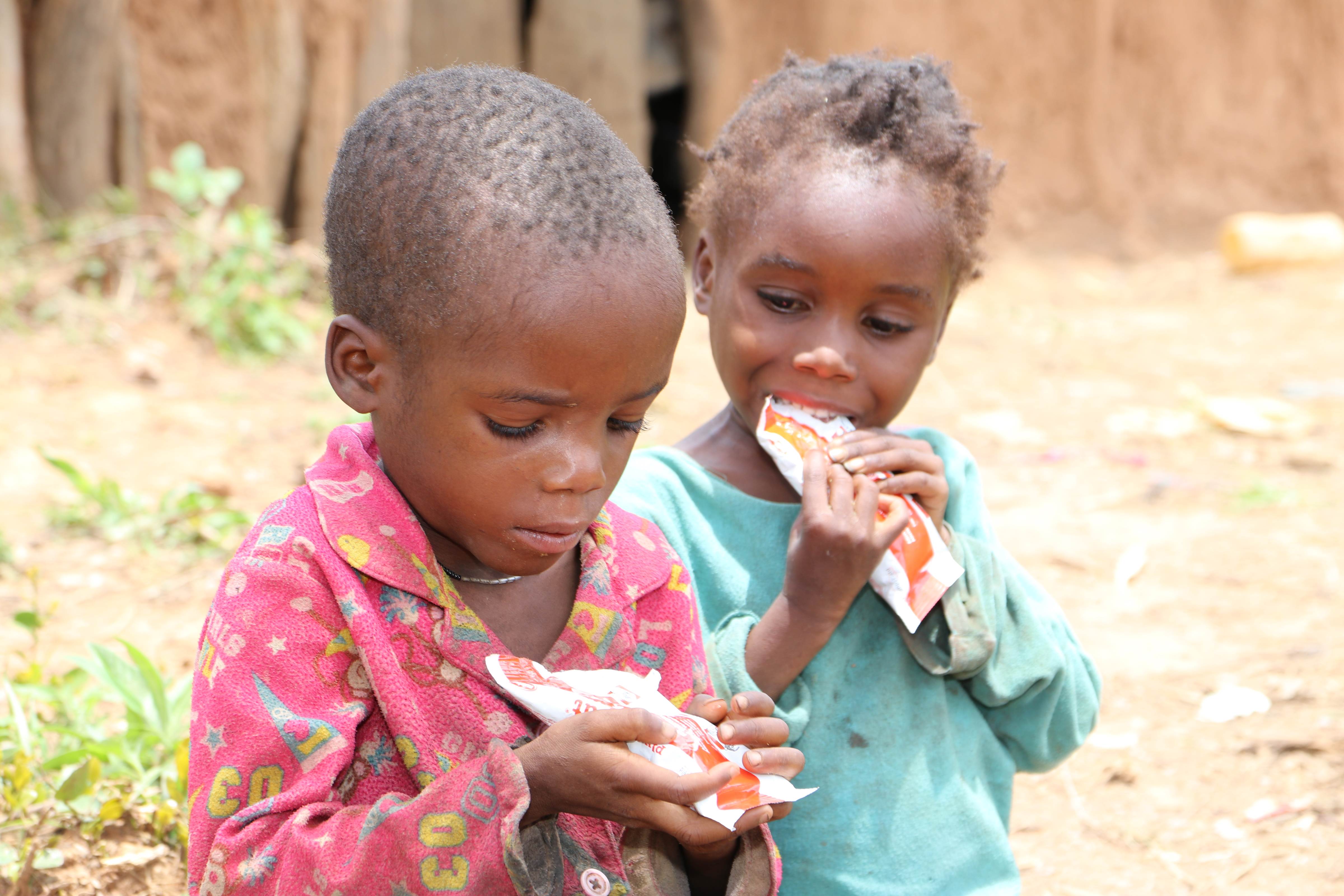 Siblings Pedro and Teresa in Angola, eagerly eat Plumpy’Nut nutritional paste, just a day after they were diagnosed with severe malnutrition