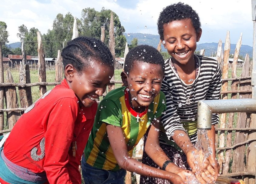 Three boys at the water tap